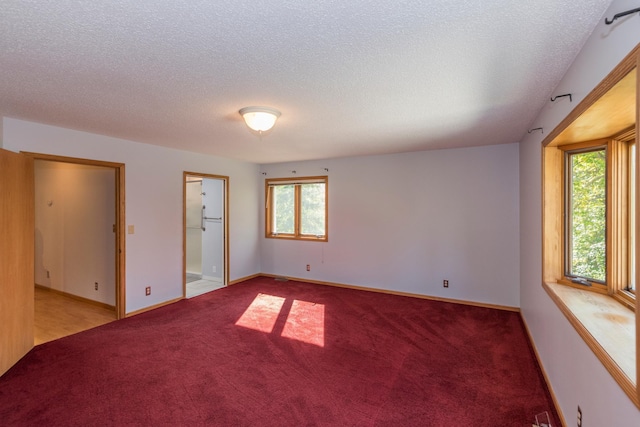 carpeted spare room with a textured ceiling