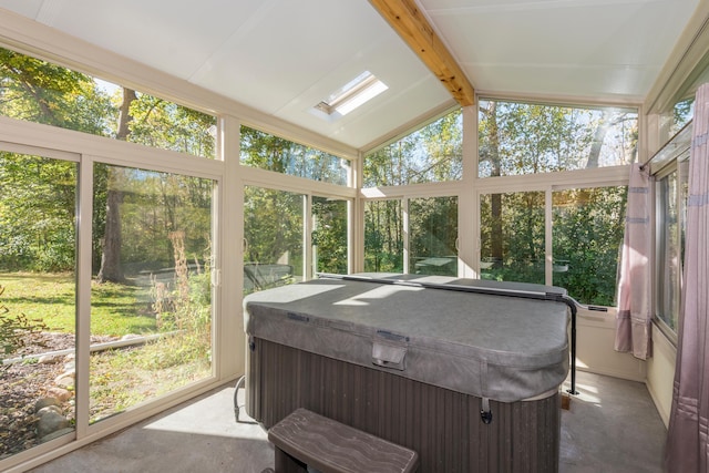 sunroom with plenty of natural light, a jacuzzi, and vaulted ceiling with beams