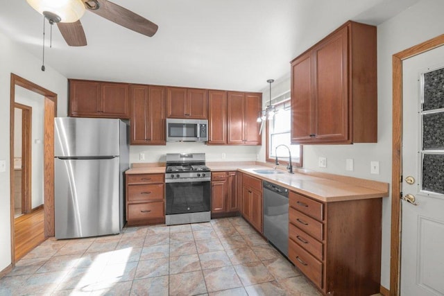 kitchen with pendant lighting, ceiling fan, appliances with stainless steel finishes, and sink