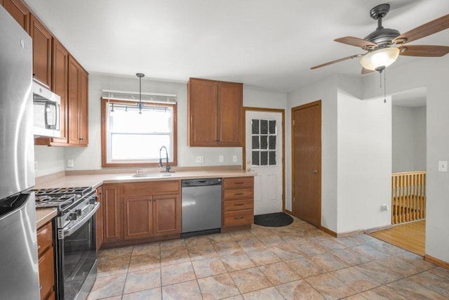 kitchen featuring stainless steel appliances, hanging light fixtures, and sink