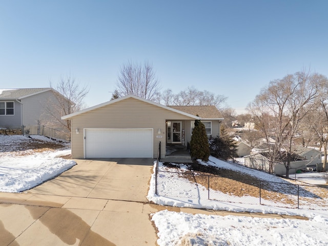 view of front of home featuring an attached garage, concrete driveway, and fence