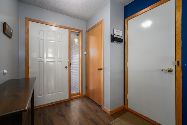 entryway featuring baseboards, dark wood-type flooring, and a textured ceiling