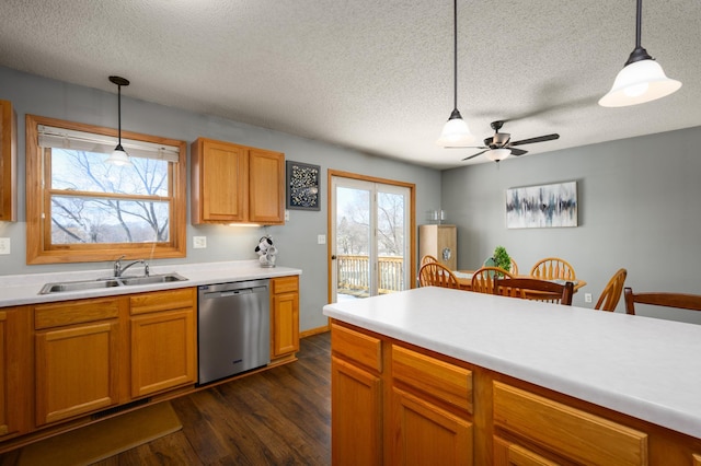 kitchen featuring a sink, dishwasher, dark wood-style flooring, and hanging light fixtures