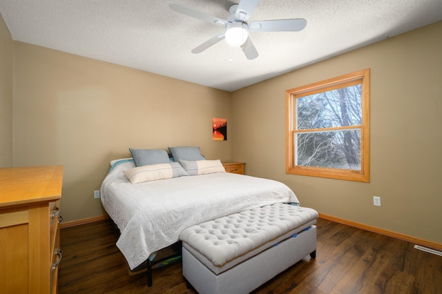 bedroom with visible vents, a ceiling fan, a textured ceiling, dark wood-style floors, and baseboards