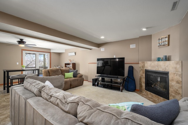 living room featuring baseboards, recessed lighting, visible vents, and a tile fireplace