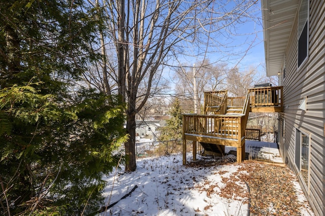 yard covered in snow featuring a wooden deck and fence