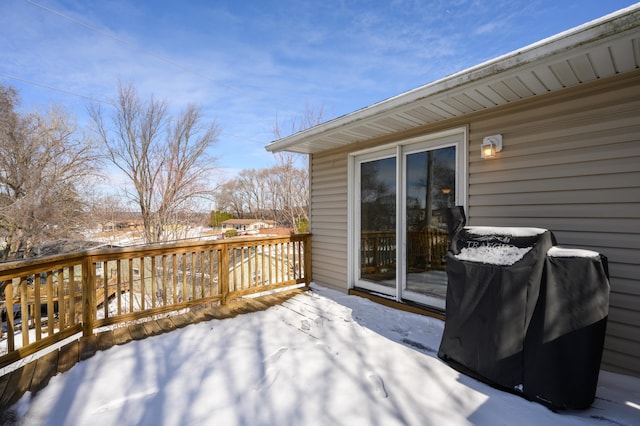 snow covered deck with a grill