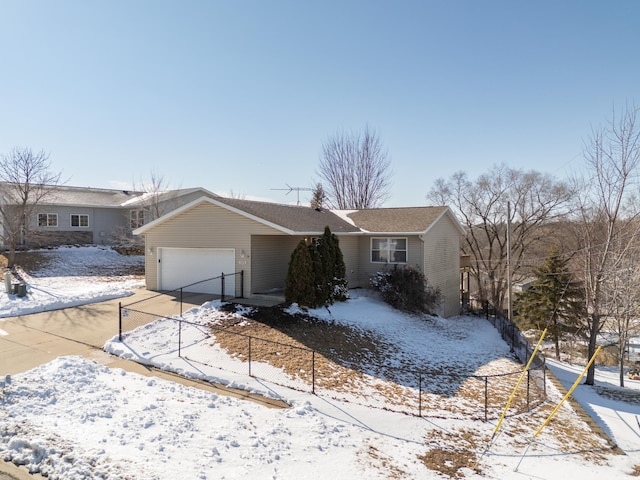 view of front of house featuring driveway, an attached garage, and fence