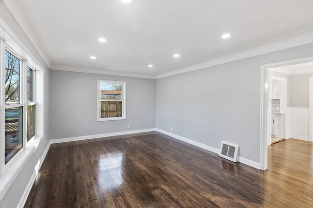 empty room featuring ornamental molding and dark hardwood / wood-style flooring