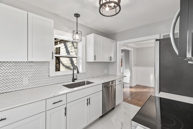 kitchen featuring sink, white cabinetry, light stone counters, hanging light fixtures, and appliances with stainless steel finishes