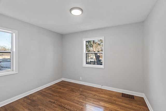 unfurnished room with dark hardwood / wood-style flooring