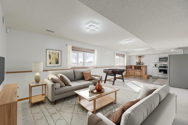 carpeted living room featuring a textured ceiling