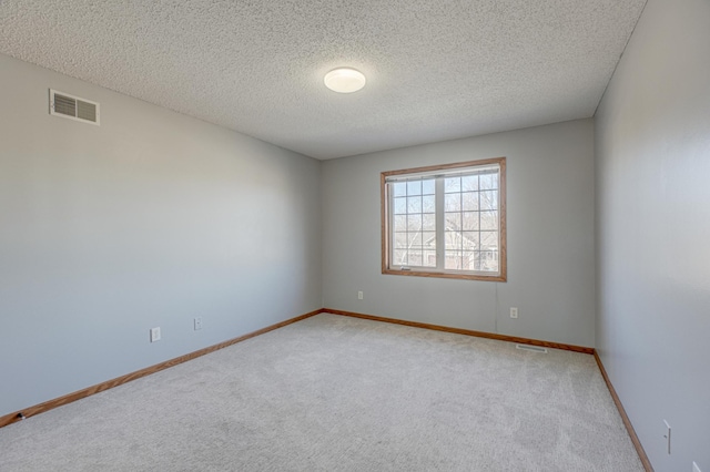 carpeted spare room featuring a textured ceiling