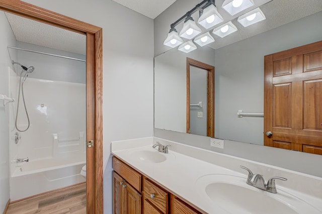 full bathroom with vanity, wood-type flooring, toilet, and a textured ceiling