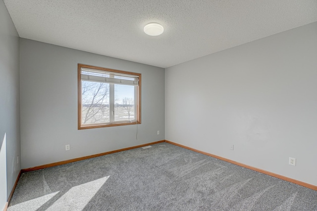 carpeted spare room with a textured ceiling