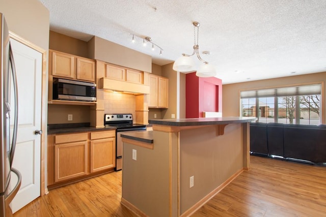 kitchen featuring light hardwood / wood-style flooring, stainless steel appliances, a kitchen breakfast bar, tasteful backsplash, and decorative light fixtures