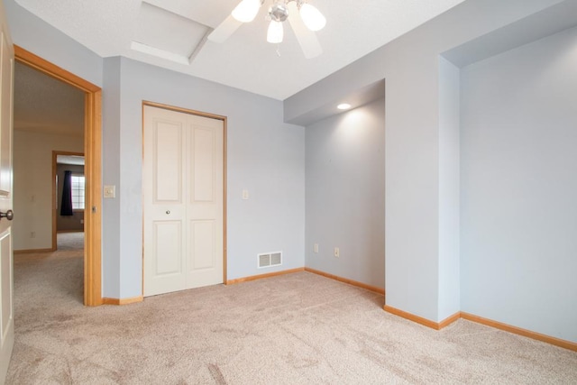 unfurnished bedroom with light carpet, ceiling fan, and a closet