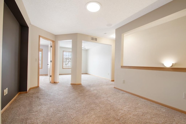 carpeted empty room featuring a textured ceiling