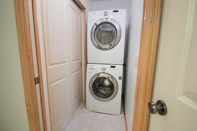 washroom featuring stacked washing maching and dryer and light tile patterned floors