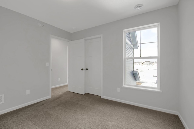 unfurnished bedroom featuring multiple windows and carpet floors