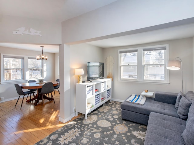 living room with hardwood / wood-style floors, a notable chandelier, and a healthy amount of sunlight