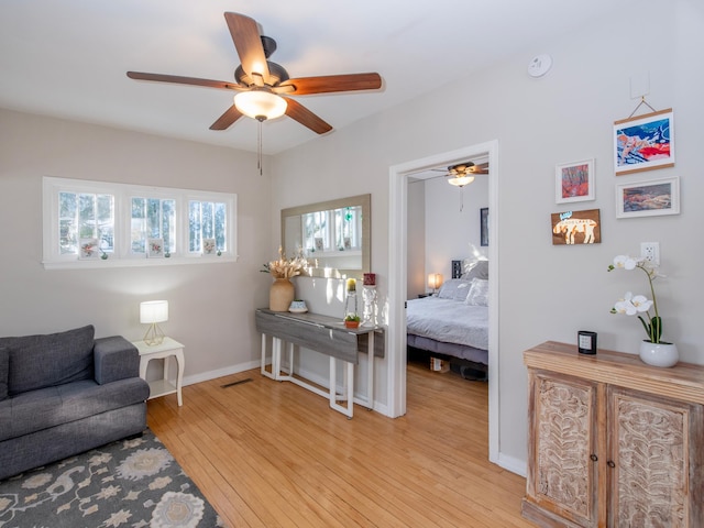 living room with ceiling fan and light hardwood / wood-style flooring