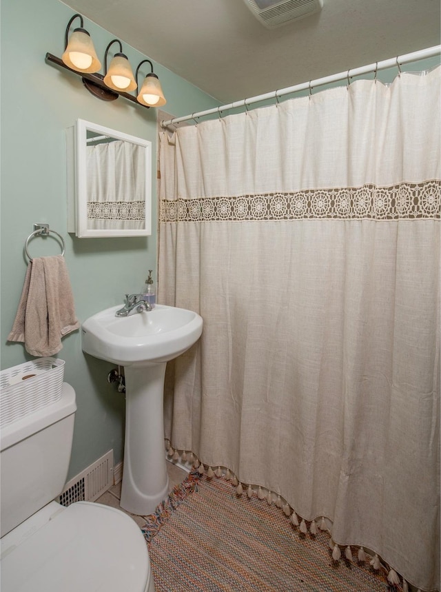 bathroom with curtained shower and toilet