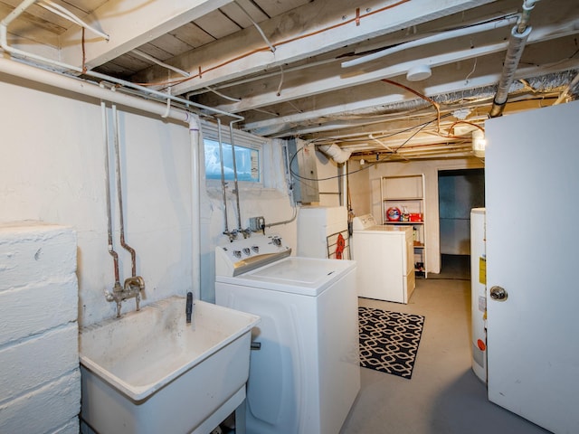 laundry area with washing machine and clothes dryer, sink, and gas water heater