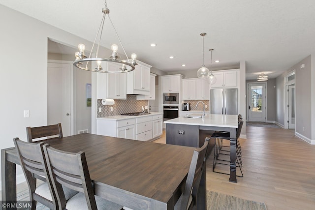 dining area featuring sink and light wood-type flooring