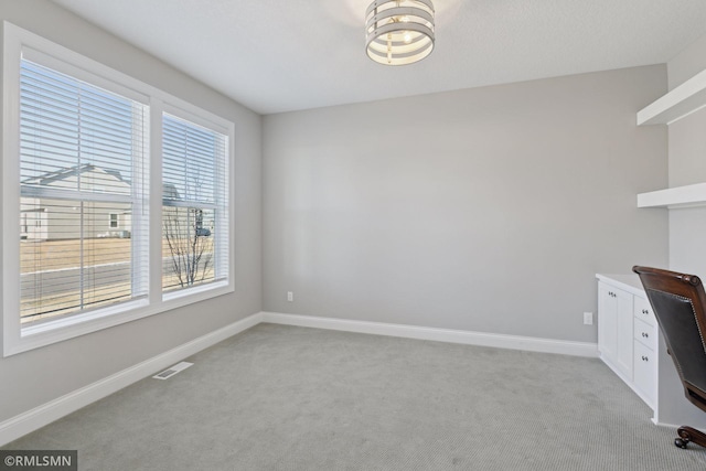 unfurnished office featuring baseboards, visible vents, and light colored carpet