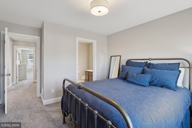 carpeted bedroom featuring ensuite bath