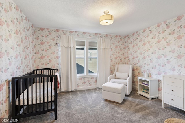 carpeted bedroom featuring a textured ceiling and a crib