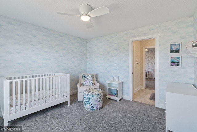 bedroom featuring carpet floors, a crib, and ceiling fan