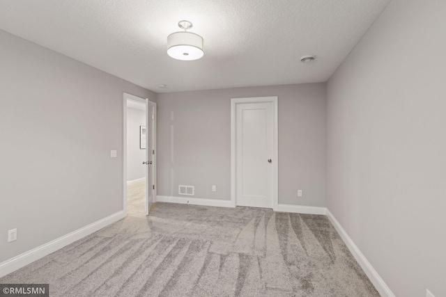 carpeted spare room with a textured ceiling