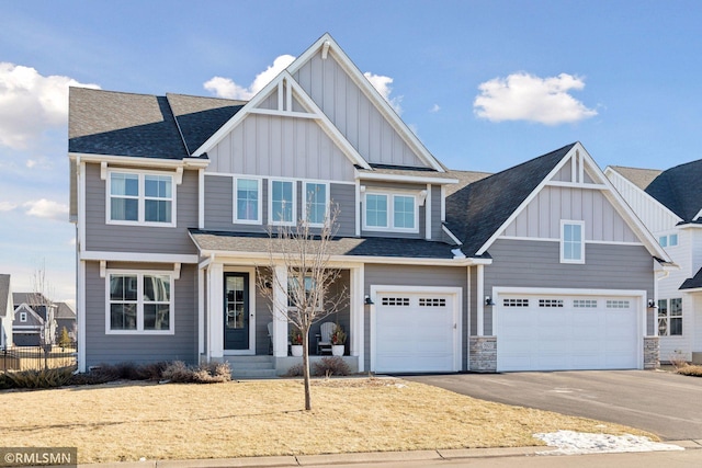 craftsman house with board and batten siding, a shingled roof, a garage, and aphalt driveway