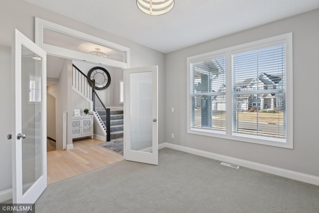 interior space featuring carpet floors, french doors, visible vents, and baseboards