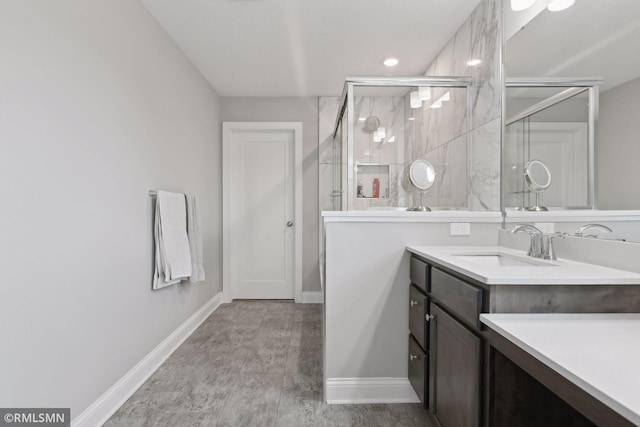 bathroom featuring a stall shower, vanity, and baseboards