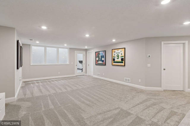 interior space featuring recessed lighting, baseboards, and light colored carpet