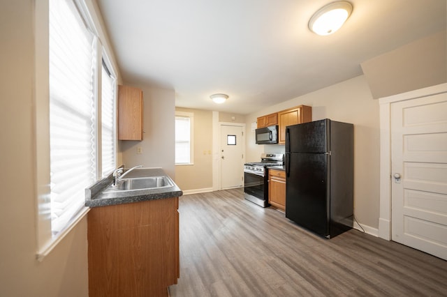 kitchen with sink, hardwood / wood-style flooring, and black appliances