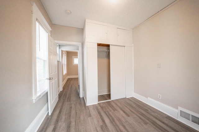 unfurnished bedroom featuring wood-type flooring and a closet