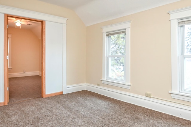 spare room with vaulted ceiling, a healthy amount of sunlight, and carpet flooring