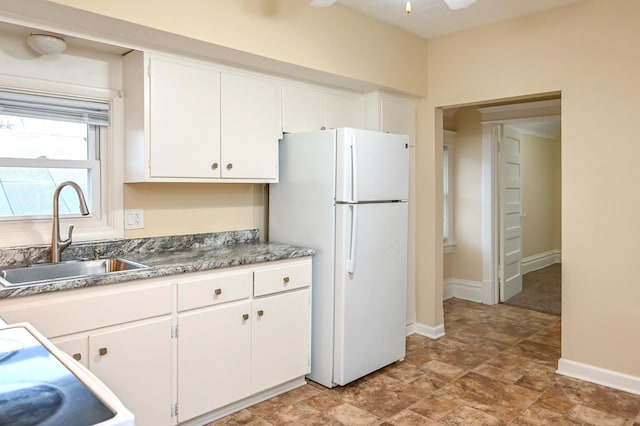 kitchen with sink, ceiling fan, white cabinets, and white refrigerator