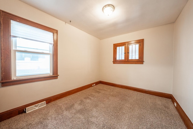 carpeted empty room with plenty of natural light