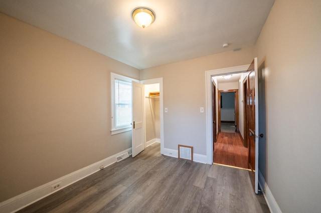 unfurnished bedroom with dark hardwood / wood-style flooring