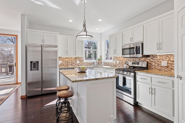 2536 Saunders Lake Dr, Minnetrista, MN 55364 - kitchen with stainless steel appliances, plenty of natural light, a center island, white cabinetry, and recessed lighting