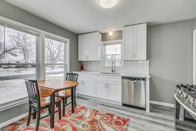 kitchen featuring white cabinetry, sink, backsplash, and stainless steel appliances