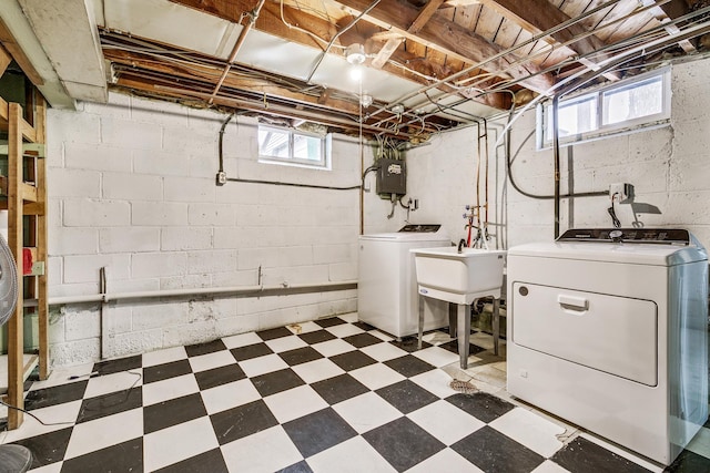 basement with sink, washing machine and clothes dryer, and electric panel