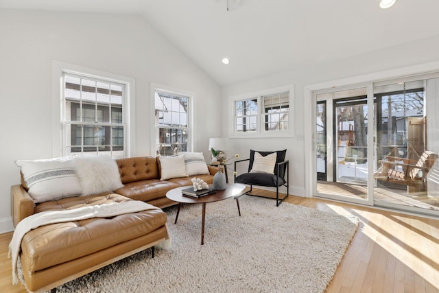 interior space with lofted ceiling, baseboards, wood finished floors, and recessed lighting