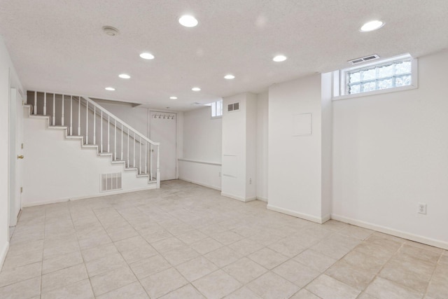 basement featuring recessed lighting, visible vents, and stairs