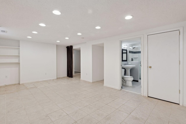 finished basement with recessed lighting, visible vents, a textured ceiling, and baseboards